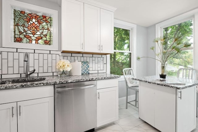 kitchen featuring white cabinets, light stone countertops, dishwasher, and sink