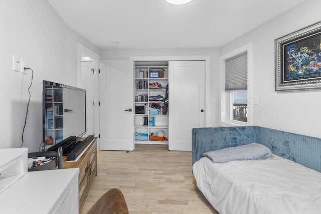 bedroom with light wood-type flooring and a closet