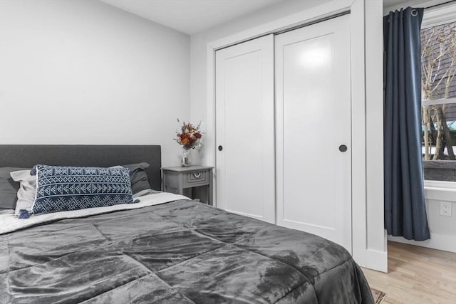 bedroom with light hardwood / wood-style floors and a closet