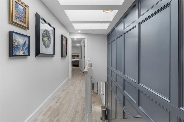 corridor with a skylight and light wood-type flooring