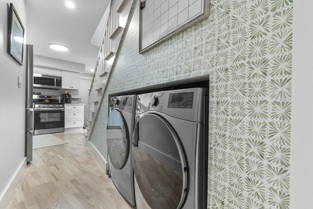 laundry room featuring separate washer and dryer and light hardwood / wood-style floors