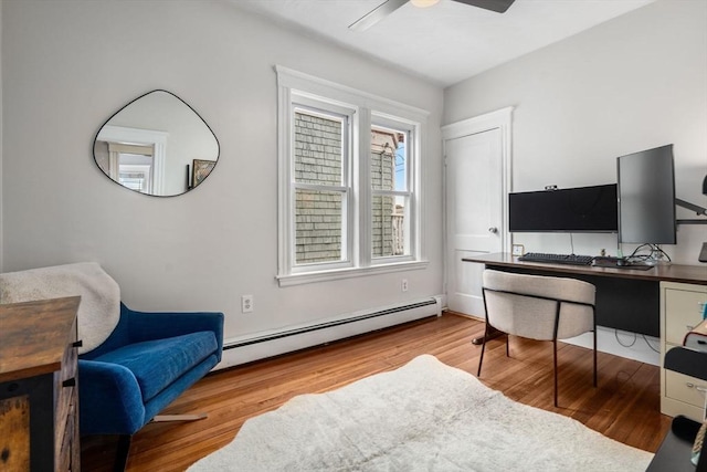home office featuring a baseboard radiator, ceiling fan, and wood finished floors