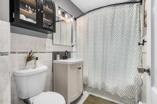 bathroom featuring toilet, tile walls, curtained shower, and vanity