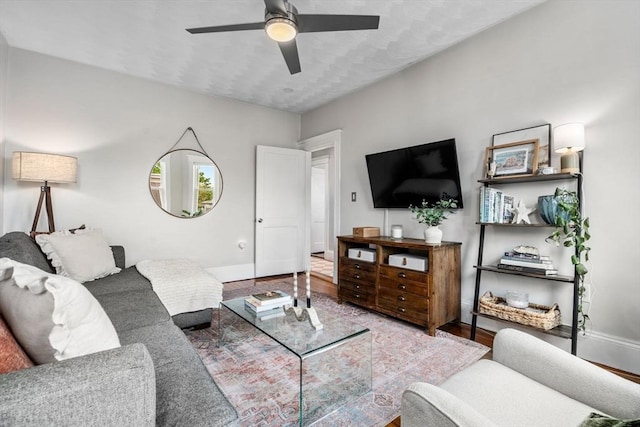 living area with ceiling fan, baseboards, and wood finished floors