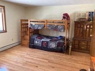 bedroom featuring a baseboard radiator and light wood finished floors