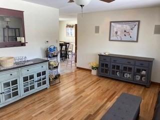 living room with ceiling fan, wood finished floors, and baseboards