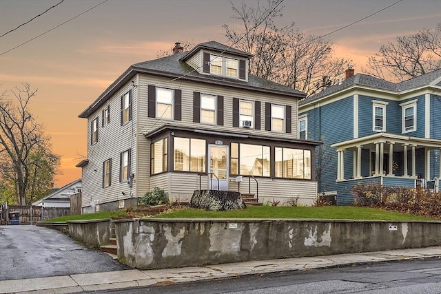 back house at dusk with a lawn