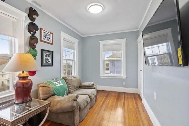 sitting room featuring hardwood / wood-style flooring, crown molding, and a healthy amount of sunlight