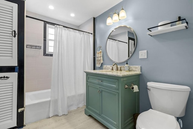 full bathroom featuring hardwood / wood-style flooring, shower / bath combination with curtain, vanity, and toilet