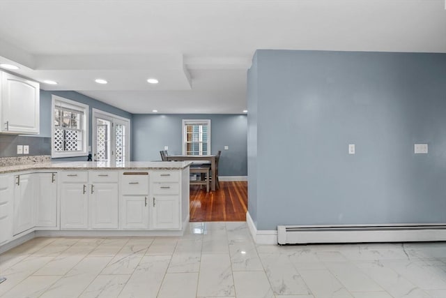 kitchen with white cabinetry, kitchen peninsula, and a baseboard radiator