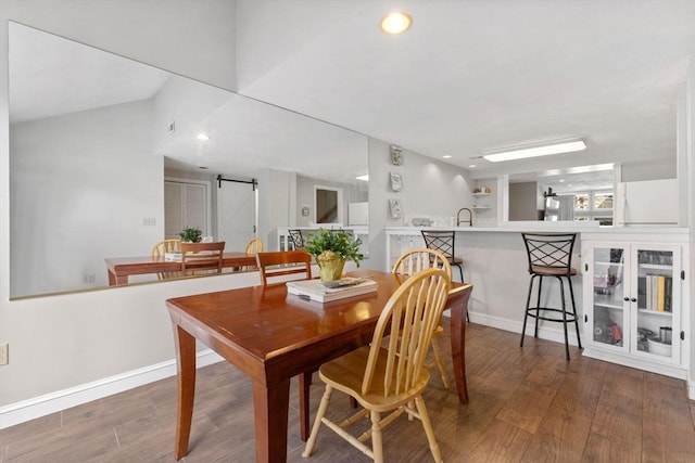 dining area with hardwood / wood-style floors, a barn door, and sink