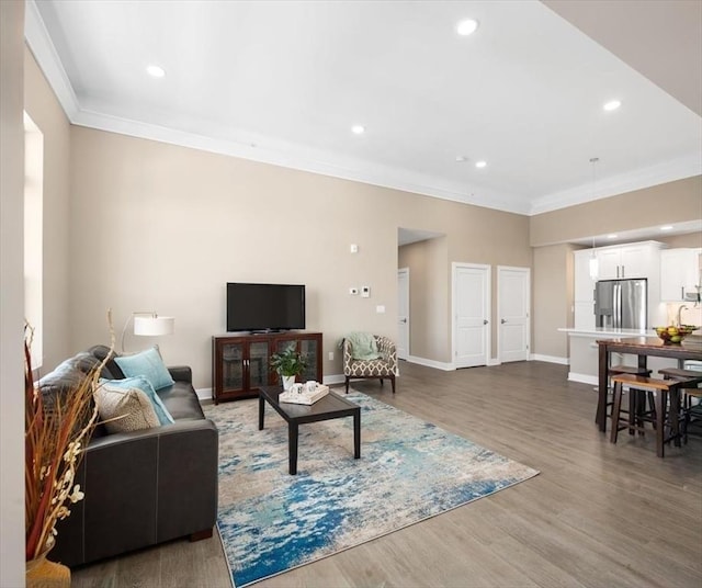 living area with recessed lighting, ornamental molding, and wood finished floors