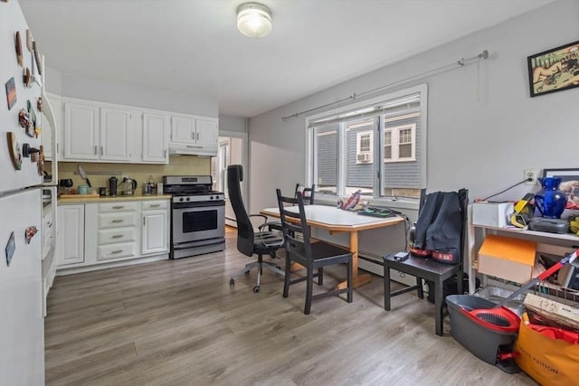 18-20 Presentation Rd, Boston, MA 02135 - kitchen with stainless steel gas stove, under cabinet range hood, white cabinets, light wood-style floors, and an office area