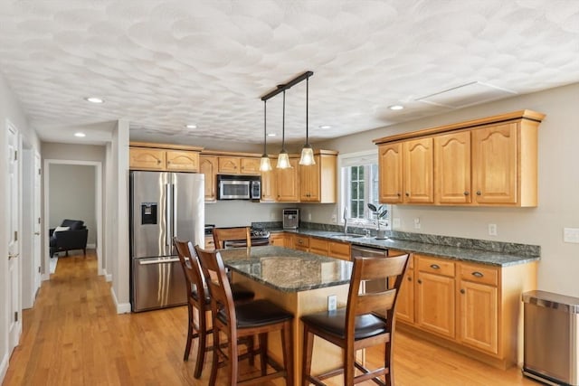 7 Acorn Way, Georgetown, MA 01833 - kitchen featuring appliances with stainless steel finishes, a sink, a breakfast bar area, light wood-style flooring, and recessed lighting