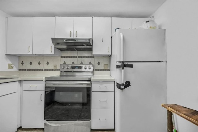 kitchen with stainless steel electric stove, white fridge, white cabinets, and backsplash