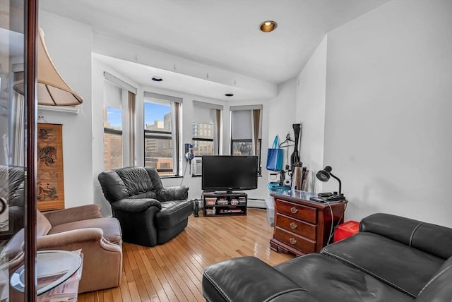 living room featuring wood-type flooring and a baseboard heating unit