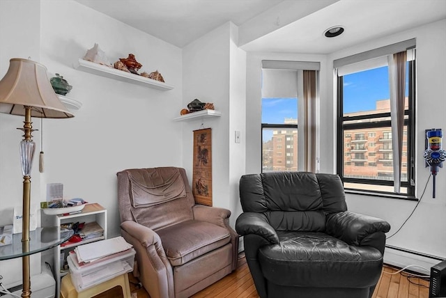 living area with light hardwood / wood-style flooring and a baseboard radiator