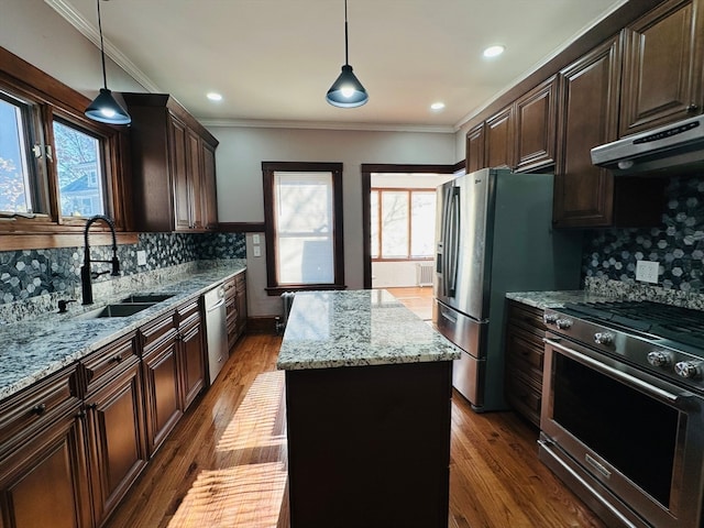 kitchen featuring decorative light fixtures, a center island, sink, and appliances with stainless steel finishes