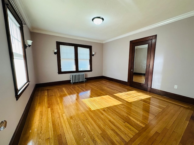 unfurnished room with radiator heating unit, hardwood / wood-style flooring, and crown molding