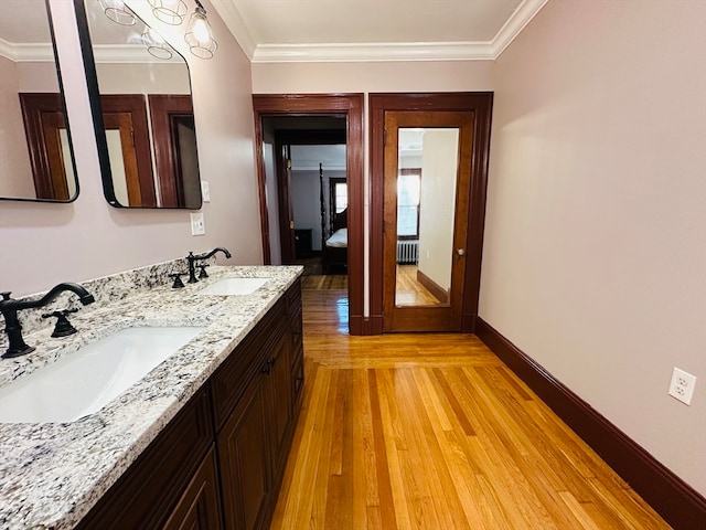 bathroom with wood-type flooring, vanity, and ornamental molding