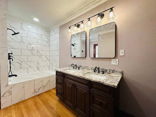 bathroom with vanity, wood-type flooring, tiled shower / bath combo, and crown molding