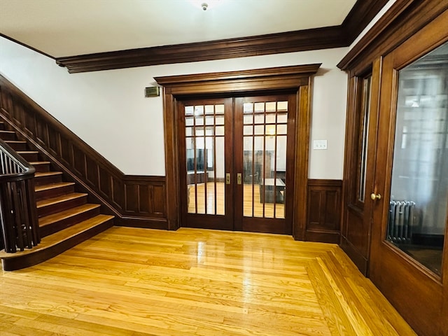 doorway to outside featuring light wood-type flooring, crown molding, and french doors