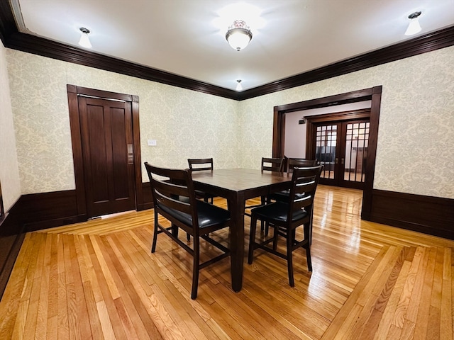 dining room with french doors, light wood-type flooring, and crown molding