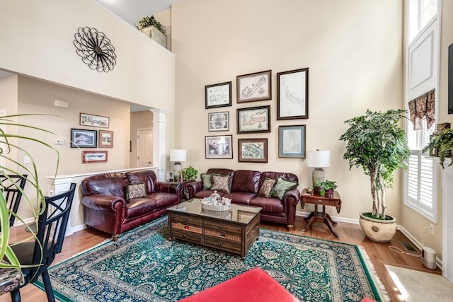 29 Shinglewood, Plymouth, MA 02360 - living area with wood finished floors, ornate columns, a towering ceiling, and baseboards