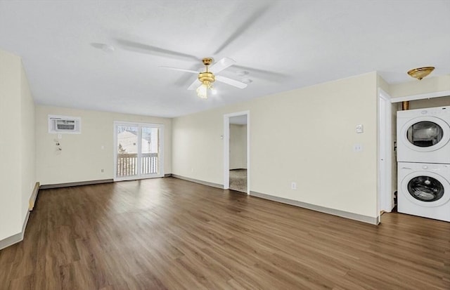 washroom featuring stacked washer / dryer, wood finished floors, a wall mounted air conditioner, ceiling fan, and baseboards