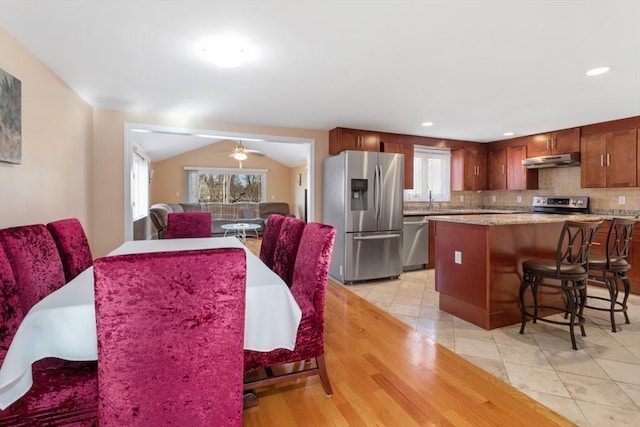 tiled dining area featuring plenty of natural light, ceiling fan, lofted ceiling, and sink