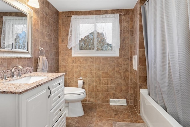 full bathroom featuring tile patterned flooring, vanity, toilet, and tile walls