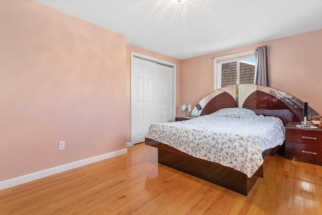 bedroom with light wood-type flooring and a closet