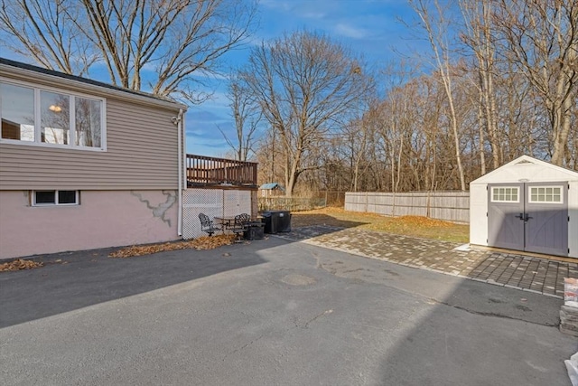 exterior space featuring a patio area, a deck, and a storage unit