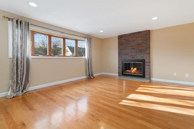 unfurnished living room with a fireplace and light wood-type flooring