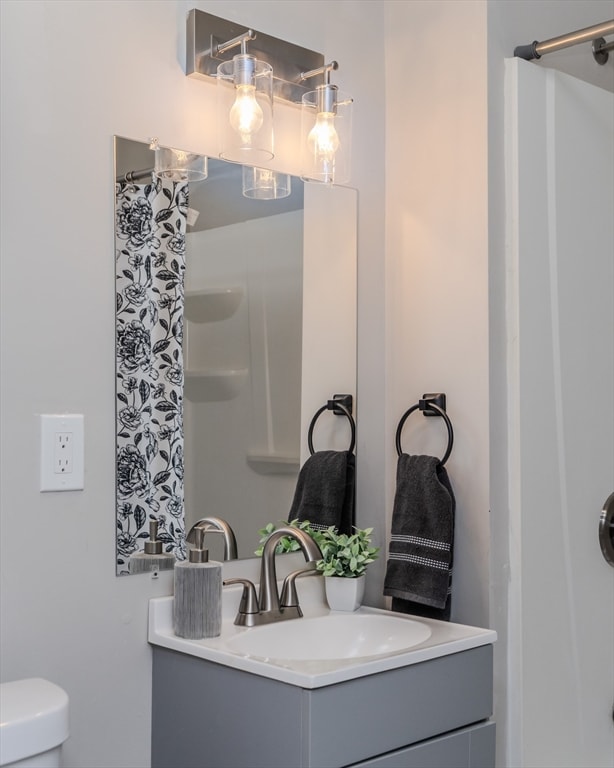 bathroom featuring vanity, toilet, and a shower with shower curtain