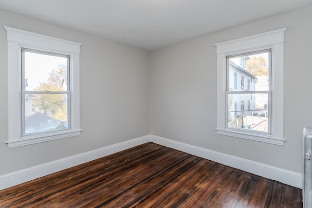 spare room with radiator and dark hardwood / wood-style flooring