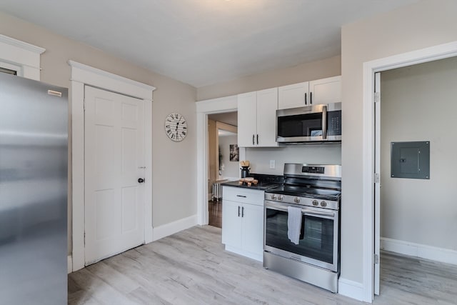 kitchen with white cabinetry, electric panel, stainless steel appliances, and light hardwood / wood-style flooring