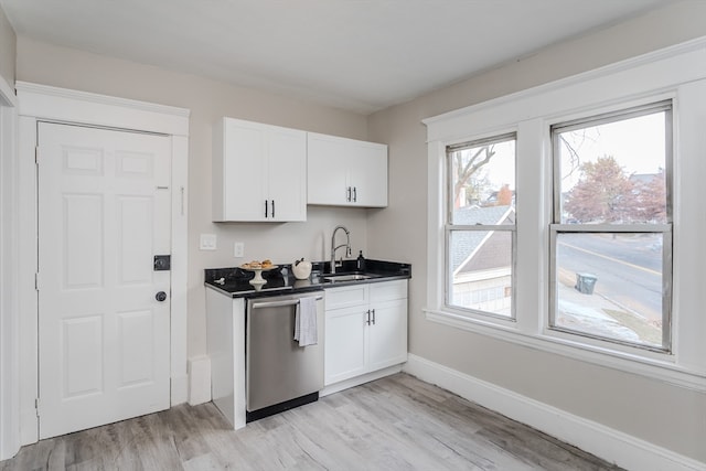 kitchen featuring stainless steel dishwasher, white cabinets, sink, and light hardwood / wood-style flooring