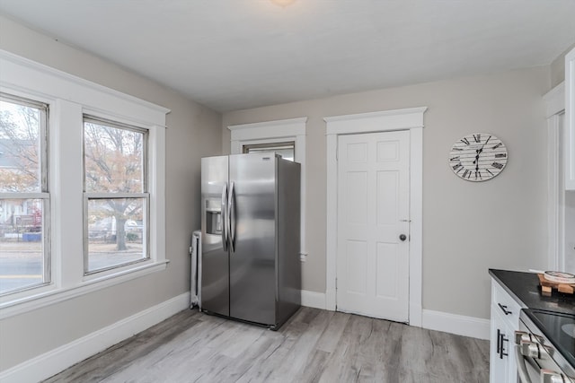 kitchen with white cabinetry, appliances with stainless steel finishes, and light hardwood / wood-style flooring