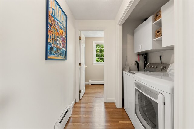 3 Penni Ln, Andover, MA 01810 - laundry room featuring cabinet space, a baseboard heating unit, baseboard heating, washing machine and dryer, and light wood finished floors