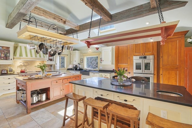 79 David Ave, Tisbury, MA 02568 - kitchen featuring double oven, a sink, open shelves, beam ceiling, and dark countertops