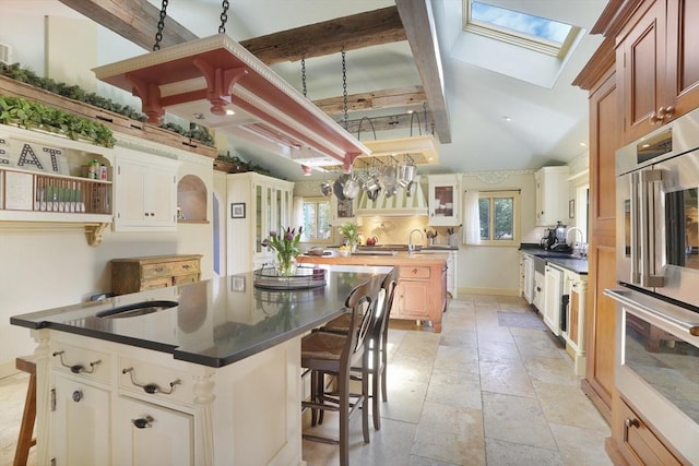 79 David Ave, Tisbury, MA 02568 - kitchen featuring a skylight, healthy amount of natural light, a center island with sink, double oven, and recessed lighting