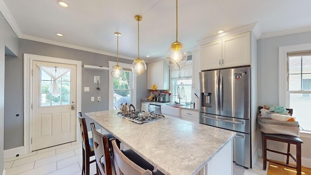 33 Jarvis St, Revere, MA 02151 - kitchen with appliances with stainless steel finishes, plenty of natural light, a kitchen island, white cabinets, and crown molding