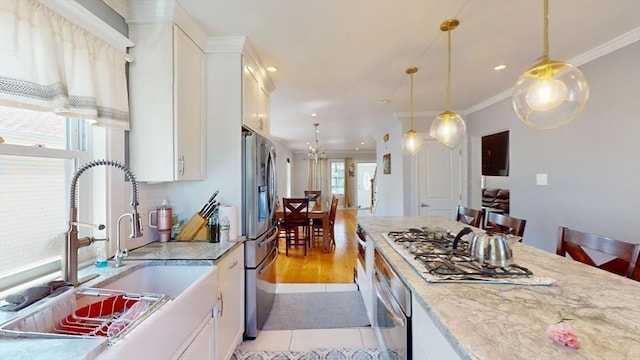 33 Jarvis St, Revere, MA 02151 - kitchen featuring appliances with stainless steel finishes, white cabinetry, pendant lighting, crown molding, and recessed lighting