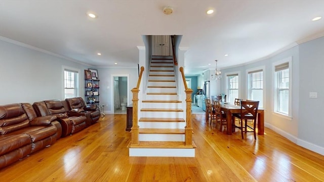 33 Jarvis St, Revere, MA 02151 - stairway with ornamental molding, a chandelier, recessed lighting, healthy amount of natural light, and wood finished floors