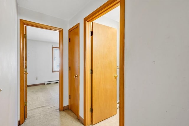 hall with light carpet, a baseboard radiator, and baseboards