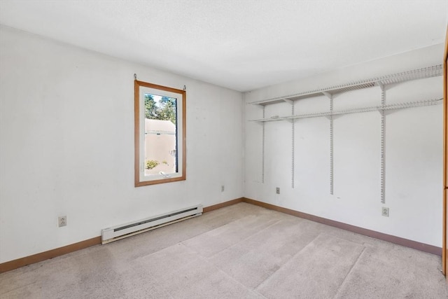 unfurnished room featuring a baseboard radiator, light colored carpet, and baseboards