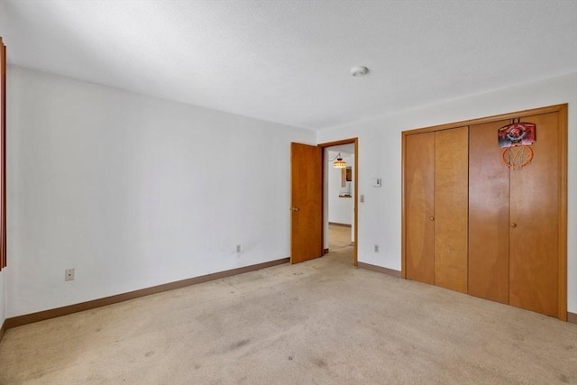 unfurnished bedroom with a closet, baseboards, and carpet flooring