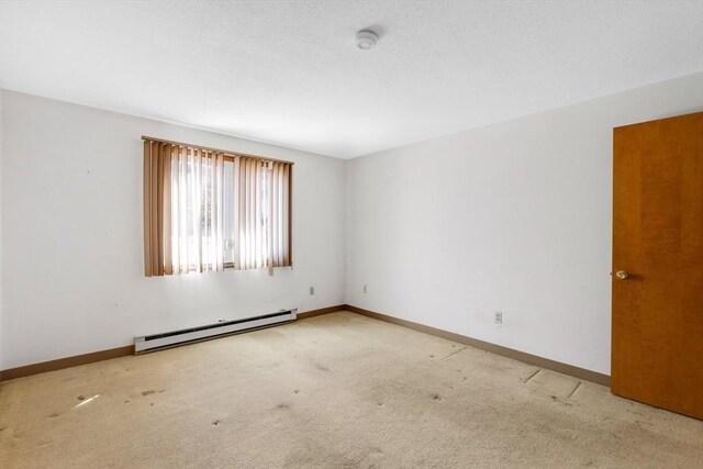 unfurnished room featuring a baseboard radiator, carpet flooring, a textured ceiling, and baseboards