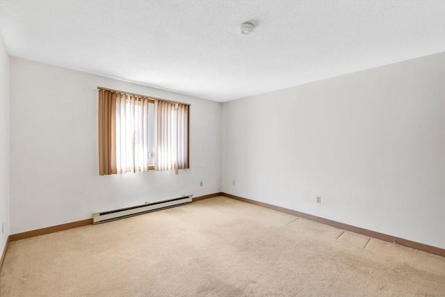 empty room featuring baseboards, light colored carpet, a textured ceiling, and baseboard heating